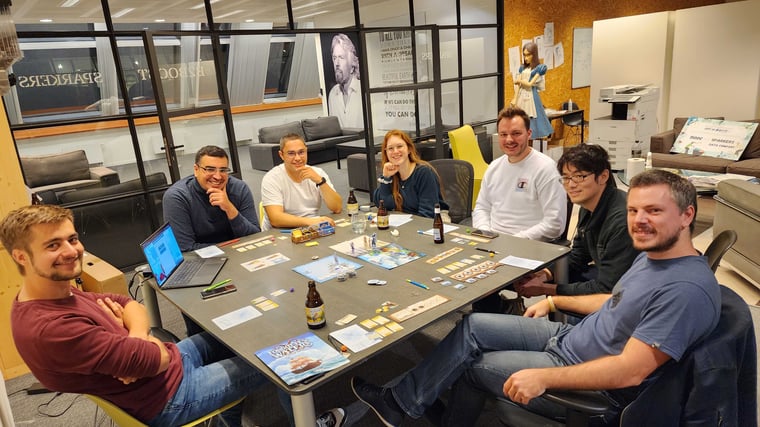 Colleagues having fun after work around a board game 